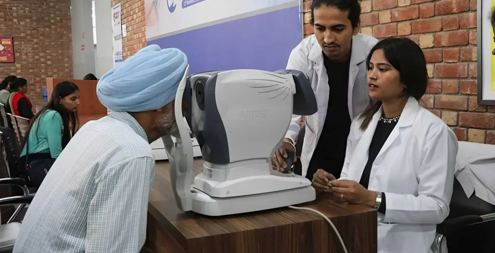 A volunteer in a lab coat testing a man's eyesight at an eye check-up camp