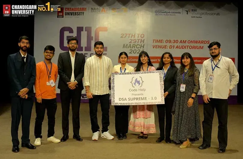 A winning team on stage holding a prize cheque