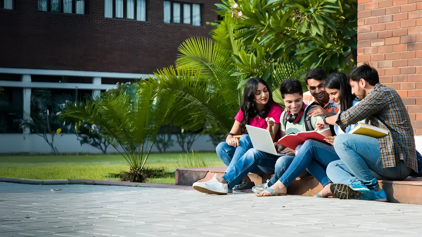 Students reading together on the steps outside a campus building