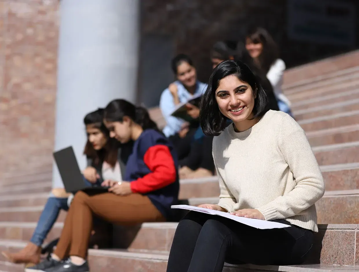Students studying on the steps of a campus building