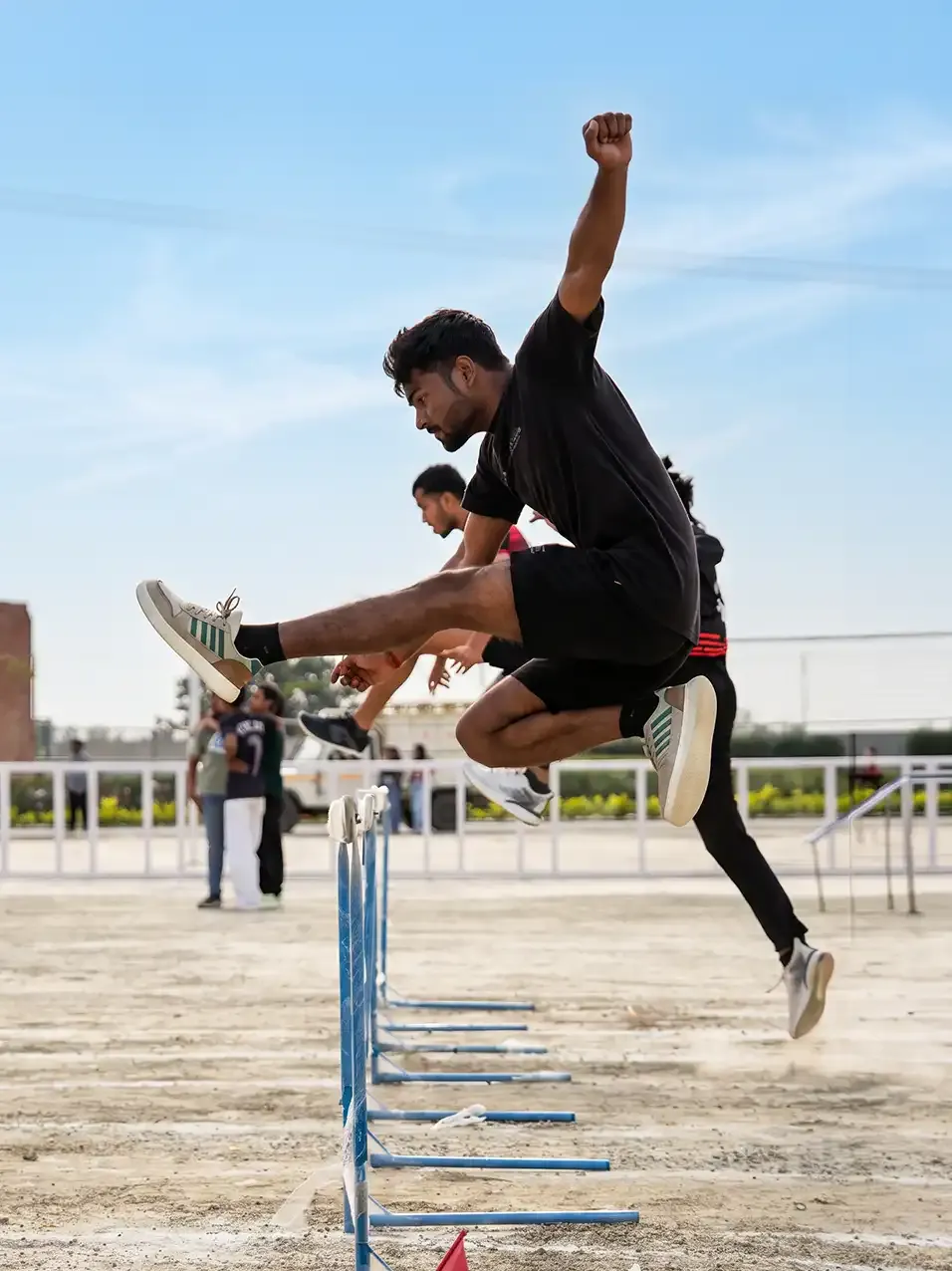 A student clearing a hurdle at the sports complex